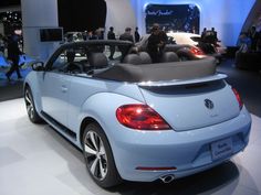 the back end of a blue convertible car on display