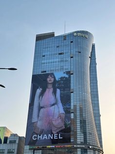 a large advertisement on the side of a tall building in front of a traffic light