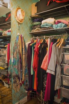 an organized closet with clothes hanging on racks