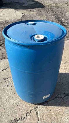 a large blue barrel sitting on top of a sidewalk