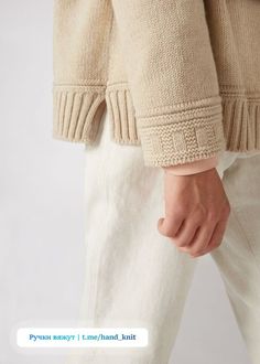 a person wearing white pants and a beige sweater