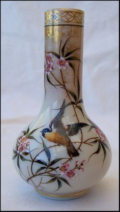 a white vase with birds and flowers painted on it