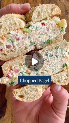 a person holding a sandwich in their hand with the words chopped bagel on it