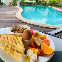 a white plate topped with food next to a swimming pool