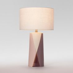 a table lamp with a white shade on it and a beige fabric lampshade