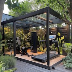 an outdoor gym with treadmills, exercise equipment and trees in the foreground