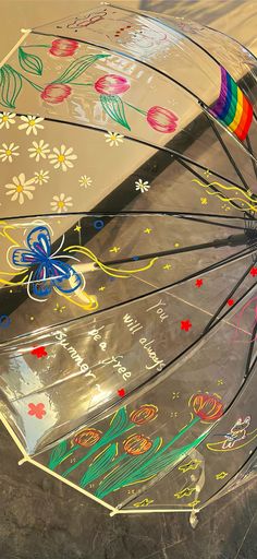 an upside down umbrella with flowers painted on it's sides and rainbow colored handles