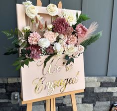 a sign with flowers on it that says we are engaged