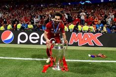 the soccer player is posing with his trophy