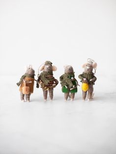 four small toy mice dressed in green and brown outfits