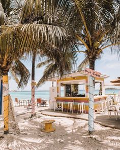 a yellow and white food stand sitting on top of a sandy beach