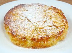 a small pastry on a white plate covered in powdered sugar