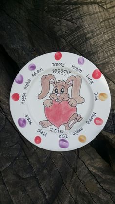 a plate with a drawing of a bunny holding a heart on it's side