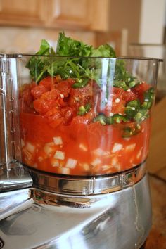 a food processor with tomatoes, lettuce and other toppings in the bowl