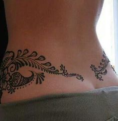 a woman's stomach with a tattoo design on the side of her body,