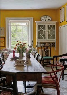 a dining room with yellow walls and chairs