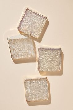 three square glass dishes sitting on top of a white countertop next to each other