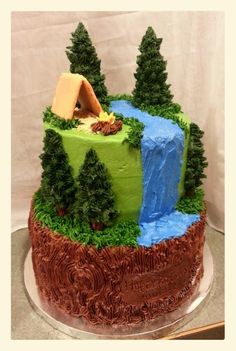 a cake decorated with trees and a stream