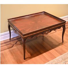 a wooden table with glass top sitting on a hard wood floor