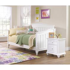 a white day bed sitting on top of a hard wood floor next to a window