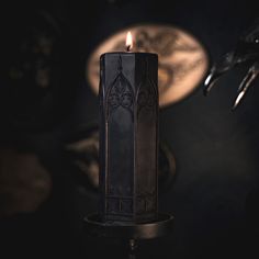 a black candle sitting on top of a table next to a skull and other items