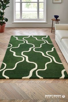 a green rug with white swirls on it in front of a window and wooden floor