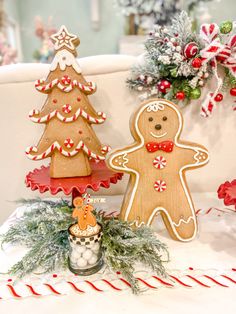 two gingerbread christmas trees, one decorated with candy canes and the other decorated with cookies