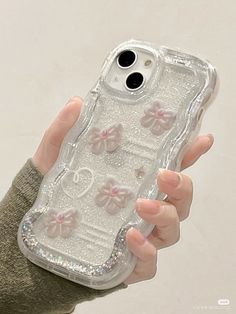 a person holding an iphone case with bows and glitters on the back in their hand