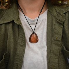 This Orange Vein Jasper pendant necklace is designed for someone with a simple style and a love for gems. The Jasper has a more masculine feel with a strong hefty shape. The colors are a blend of brownish red and orange with Quartz veins running through the entire piece. The adjustable hypoallergenic vegan necklace makes it easy to take on and off. 1.4 inches in total length 1.25 inches wide .4 inches thick Comfortable and smooth Medium to heavier weight Made with Washington State Orange Vein Ja Carnelian Jewelry, Jasper Jewelry, Zodiac Signs Aries, Quartz Jewelry, Eco Friendly Paper, Red And Orange, Agate Jewelry, Jasper Pendant, Moonstone Jewelry