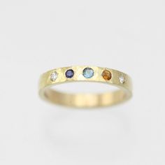 A colorful way to wear your family's birthstones! This ring is hand fabricated in solid 14ky gold and customized to use any number and combination of birthstones. The hammered texture gives the gold an extra glimmer! The ring is 3mm wide and 1.5mm thick. The stones are arranged in a straight line. Choose your ring size and desired number of birthstones when adding this item to your cart. Also, note the birthstone order from left to right in the text box. Please allow up to 14 business days for fabrication. Looks great stacked!!  Comes with a lifetime warranty, polishing cloth, and a gift box. All stones are synthetic except for Garnet, Amethyst, Peridot and Citrine which are natural. Feel free to ask for a price quote with all natural stones. Also available in sterling silver: https://www. Mothers Ring 3 Stone, Family Birthstone Ring, Mother's Ring, Pearl Drop Pendant, Hammered Gold Ring, Stacked Rings, Bespoke Rings, Mother Rings, Price Quote