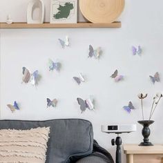 a living room filled with furniture and lots of butterfly decorations on the wall above it