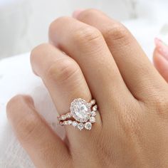 a woman's hand with a diamond ring on top of her finger and an engagement band