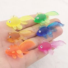 five small plastic fish on a person's palm