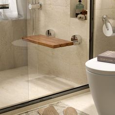 a bathroom with a wooden shelf on the side of the shower door next to a toilet