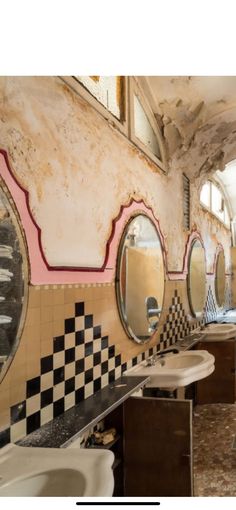 an old bathroom with checkered tile and mirrors on the wall, as well as sinks