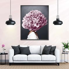 a living room with a white couch and pink flowers on the wall in front of it