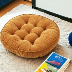 a brown chair sitting on top of a white rug next to a blue stuffed animal