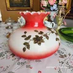 a red and white vase sitting on top of a table