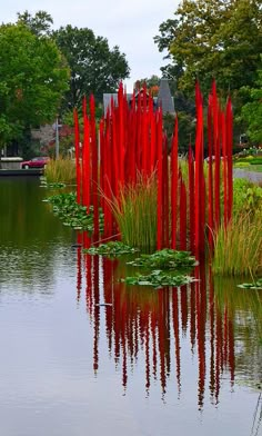 red sculptures are in the middle of a pond