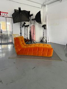 an orange couch sitting in the middle of a room