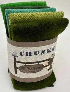 three green towels are stacked on top of each other in a bucket with the words chunk's written on it