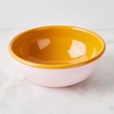 a yellow and white bowl sitting on top of a table