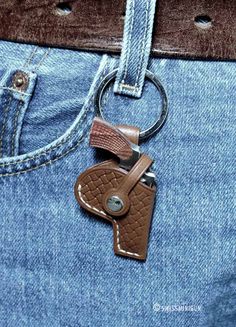 a brown leather keychain hanging from the back pocket of a pair of jeans