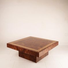 a square wooden table sitting on top of a white floor