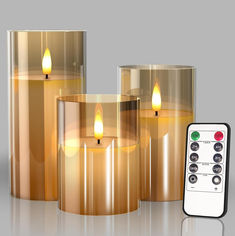 three lit candles with remote controls next to them