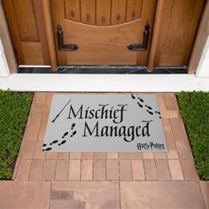 a harry potter door mat is on the front steps of a house with wood doors