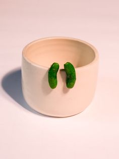 two peas are in the middle of a bowl with their tops turned upside down,