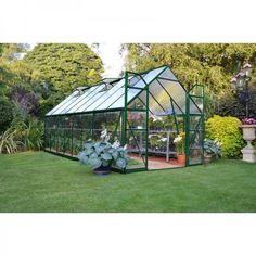 a green house in the middle of a garden