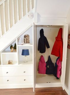 an open closet with coats hanging on the wall