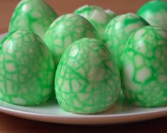 green and white decorated eggs on a plate